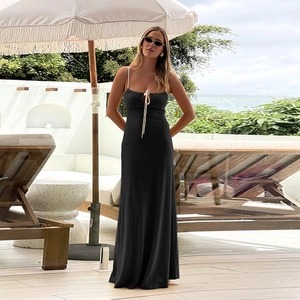 Robe longue en maille noire avec bretelles dans un décor de station balnéaire