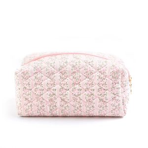 Pink floral quilted makeup bag with gold zipper closure on a clean white background