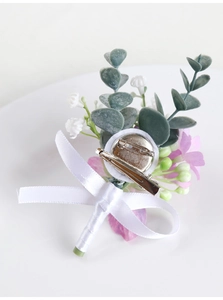 Detail of wedding boutonniere featuring silk bow and dual metal clip attachment
