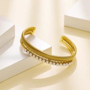 Gold stainless steel open bangle with V-shaped engraving and side pearl accents