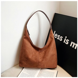 Detail of a large brown suede shoulder bag in a minimalist aesthetic interior setting