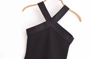 Détail d'une robe dos nu noire avec bretelles croisées et tissu à texture côtelée