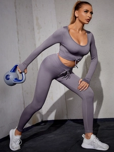 Detail of deep purple ribbed knit yoga set featuring drawstring waist and crop top design