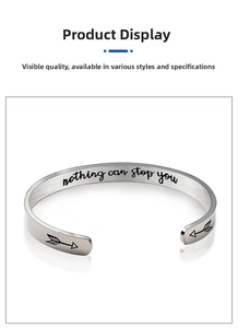 Macro detail of silver stainless steel cuff bracelet with engraved inspirational quote