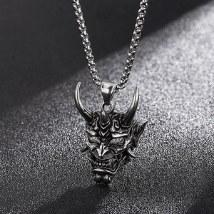 Macro detail of a vintage silver-colored horned ghost mask pendant in stainless steel