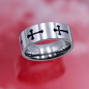 Macro shot of silver titanium ring with black cross patterns and polished finish