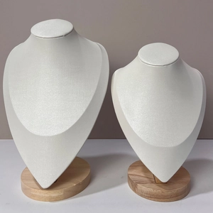 Close-up of beige necklace display busts with natural beech wood round bases