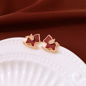Close-up of 18K gold plated rocking horse stud earrings with red enamel and crystals