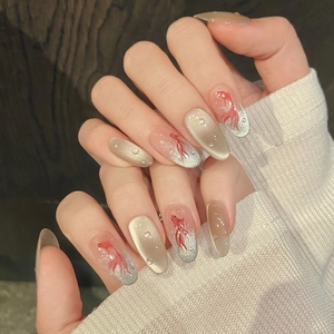 Long oval press-on nails with champagne cat eye effect and red koi fish hand-painted art
