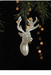 Ornement tête de renne blanc nacré avec paillettes argentées sur branche de pin