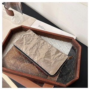 Detail of champagne gold zip-around wallet featuring a unique crinkled paper texture finish