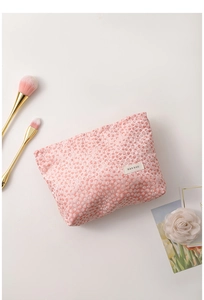 Close-up of pink floral jacquard cosmetic bag with H&R BAG label on white background