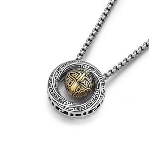 Macro shot of silver Mobius ring necklace with gold spinning bead and cloud patterns