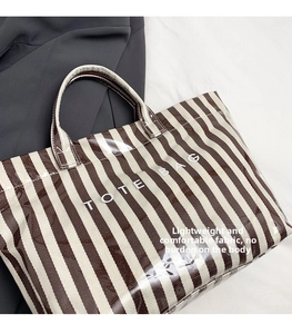 Détail du sac cabas rayé imperméable avec finition brillante et lettrage imprimé