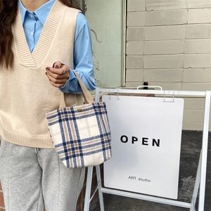 Detail of vintage plaid tote bag featuring thick wool fabric and sturdy woven handles