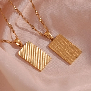 Detailed close-up of 18K gold-plated rectangular wave and diamond texture pendants