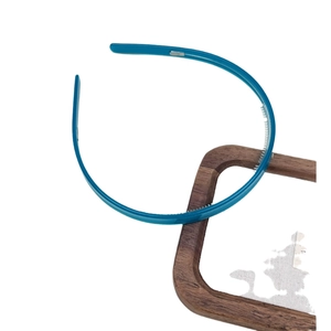 Serre-tête minimaliste en acétate bleu pour femme sur un support de présentation en bois