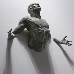 Scultura artistica in stile bronzo di un potente torso maschile che emerge dal muro