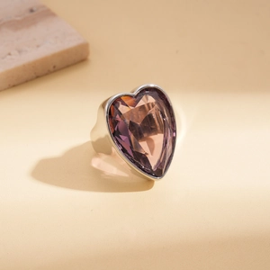 Détail d'une bague argentée épaisse ornée d'un grand cristal violet en forme de cœur