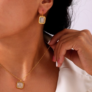 Elegant gold-plated jewelry set with square resin pendants shown on a model
