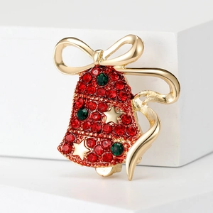 Christmas bell brooch with red crystals and gold star on white background