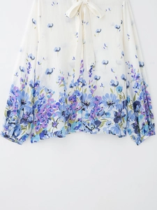 Close-up detail of the elegant bow tie neckline on the white floral print shirt