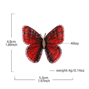 Broche papillon brodée dégradé rouge et noir avec corps en alliage doré sur fond blanc