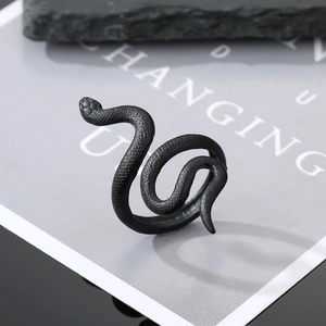 Macro detail of gothic black snake ring with matte finish on decorative stone base