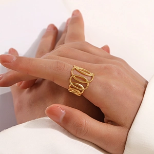 Golden multi-layer spiral ring with hollow geometric design worn by a female model
