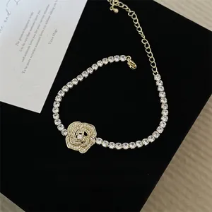 Elegant gold rose bracelet with cubic zirconia crystals on a black textured background
