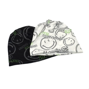 Detail of knit beanies featuring graffiti smile patterns and Sun Can't Compare text