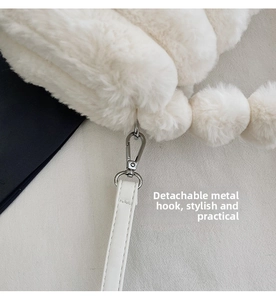 Detail of white plush handbag featuring silver metal clasp and leather strap
