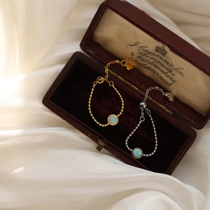 Macro shot of adjustable bead chain bracelets with fiery round opal stones in a gift box