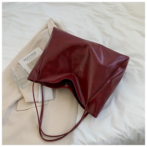 Detail of burgundy PU leather tote bag showing glossy texture and large capacity design