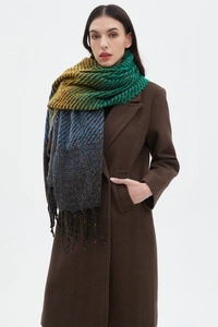 Detailed view of long tassels on a multi-color knit shawl paired with a winter wool coat