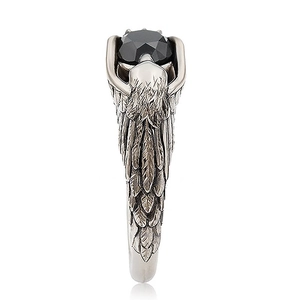 Close-up of retro eagle feather ring with black faceted gemstone and silver finish