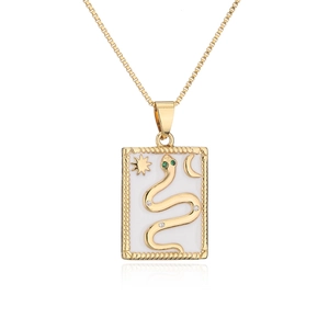 Macro shot of gold-plated snake totem pendant with zircon accents and sun moon motifs