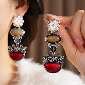 Detail of vintage long flower earrings with pearl white amber and garnet red drop stones
