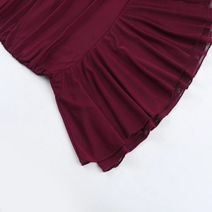 Détail de la robe en tulle bordeaux montrant l'ourlet à volants et le tissu drapé