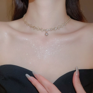 Close-up of sparkling zircon geometric pendant necklace worn on neck with silver glitter