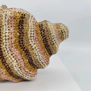 Macro side view of luxury shell-shaped clutch bag with multi-colored crystals