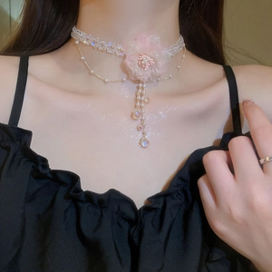 Detailansicht eines rosa Tüllblumen-Chokers mit Perlen und hängenden Quasten-Details