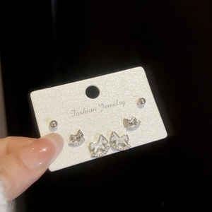 Détail de l'ensemble de boucles d'oreilles cheval à bascule argentées et zircons