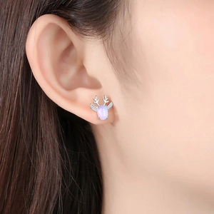 Elegant reindeer stud earrings with purple opal stone and silver plating on model