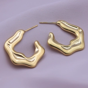Close-up of gold 18K plated stainless steel earrings with irregular molten texture design