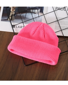 Macro detail of the bright pink chunky knit texture on a warm winter beanie hat