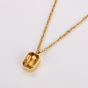 Macro shot of gold rope chain with rectangular amber sugar cube gemstone pendant