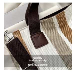 Macro detail of striped woven tote bag featuring reinforced leather patches and metal hooks