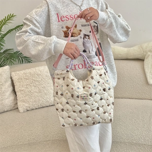 Close-up of quilted white tote bag featuring cartoon bread dog prints and fabric handles