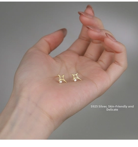 Detail of S925 sterling silver hollow star stud earrings with a sparkling zircon stone